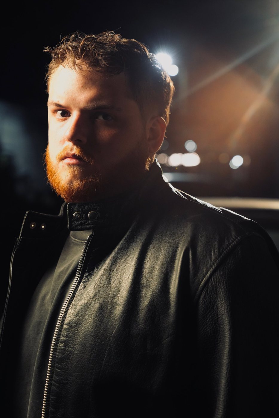 Portrait of Tanner Castille at night in a black leather jacket