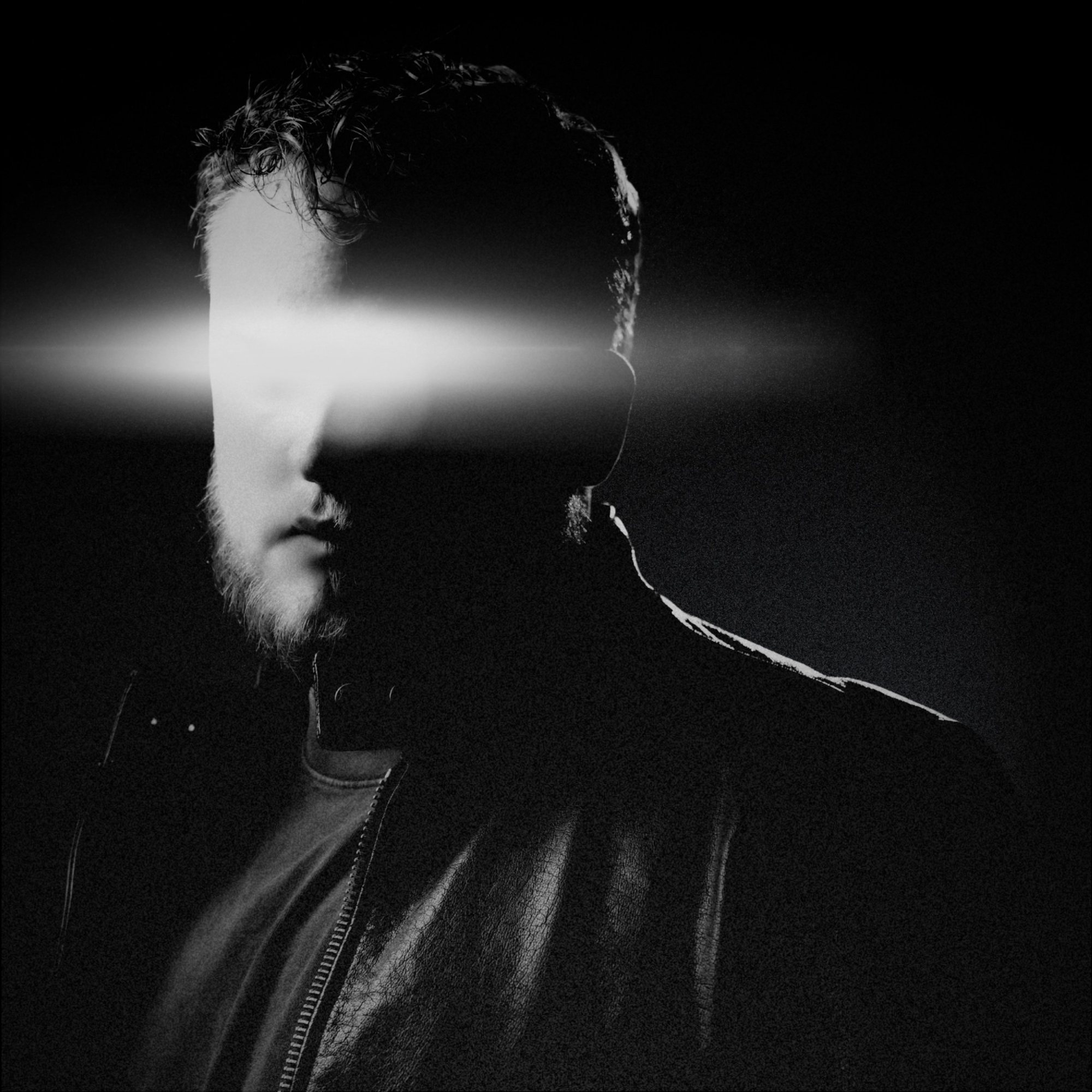 Tanner Castille in a leather jacket, a beam of light across his eyes